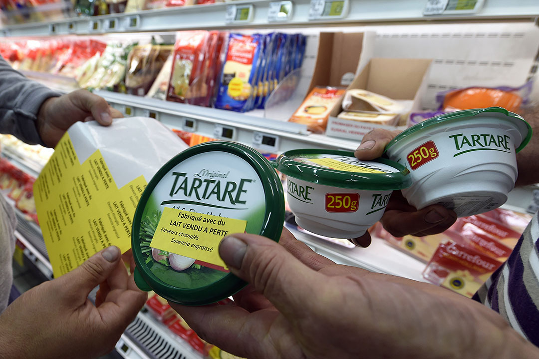 Enkele jaren geleden voerden Franse boeren actie met stickers op producten van Savencia. Het bedrijf zegt zich ondanks de coronacrisis te houden aan afspraken om boeren beter te belonen. - Foto: ANP