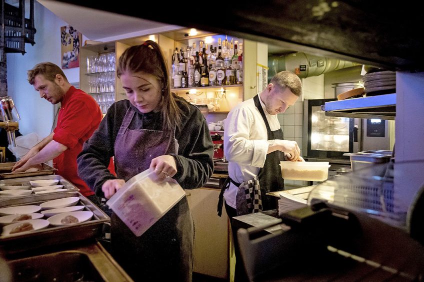Personeel van een restaurant maakt afhaalmaaltijden klaar. In de horeca werken veel ZZP’ers die zichzelf aan de eigenaar verhuren. Foto: ANP