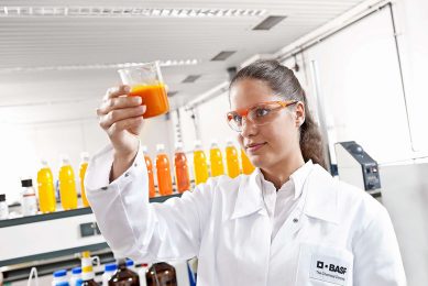 BASF-medewerkster Ines Nirk controleert in hoeverre een oranje caroteen-toevoeging zich gelijkmatig verspreid door een drankje.  - Foto: BASF