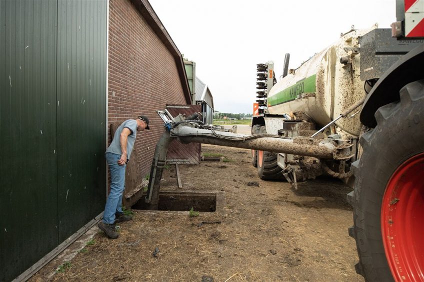 Een loonwerker pompt mest uit de mestkelder om uit te rijden op het land. - Foto: ANP